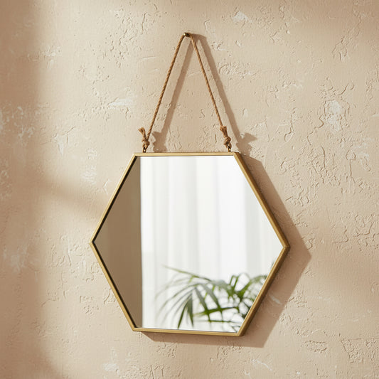 large gold geometric wall mirror with metal frame arranged on gallery wall