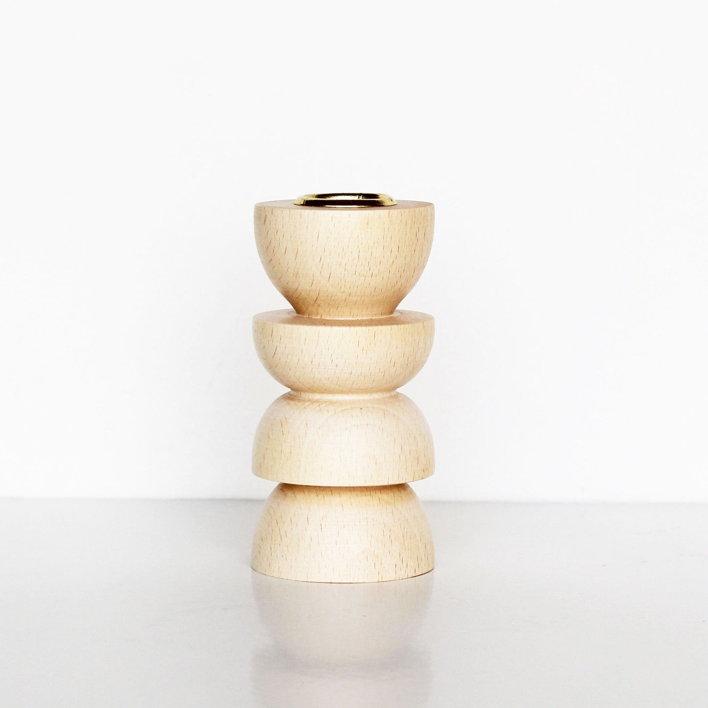 wooden candle holder with sculptural shape and brass insert